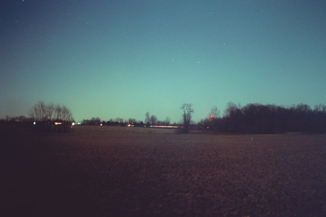 ufo flying over field at night